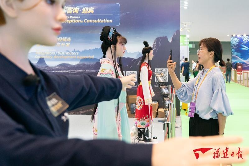 嘉宾与人形机器人互动。福建日报记者 王毅 摄