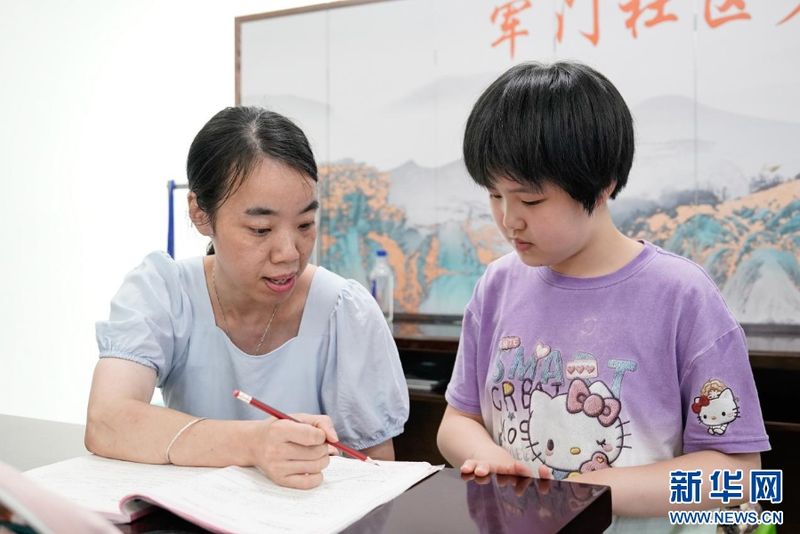 辅导老师给孩子讲解作业。新华网 蒋巧玲 摄