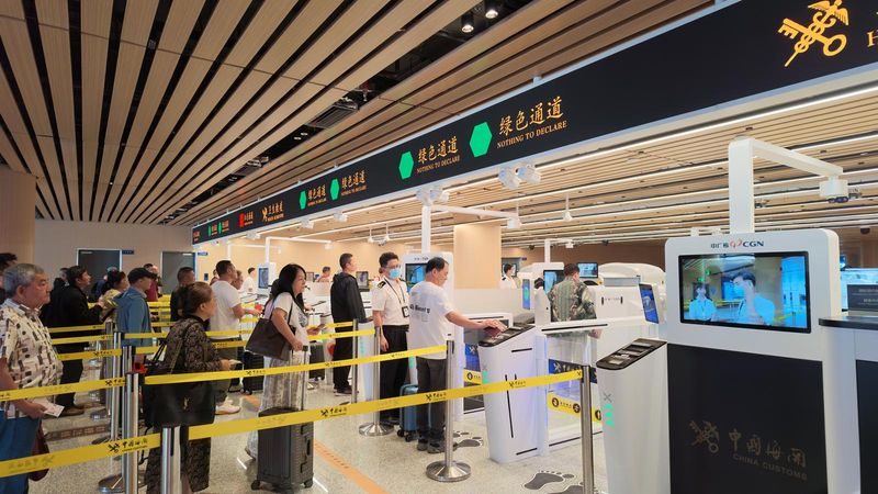 福州长乐机场海关关员引导旅客通过全新手提行李预检一体化查验通道通关。池媛婷 摄