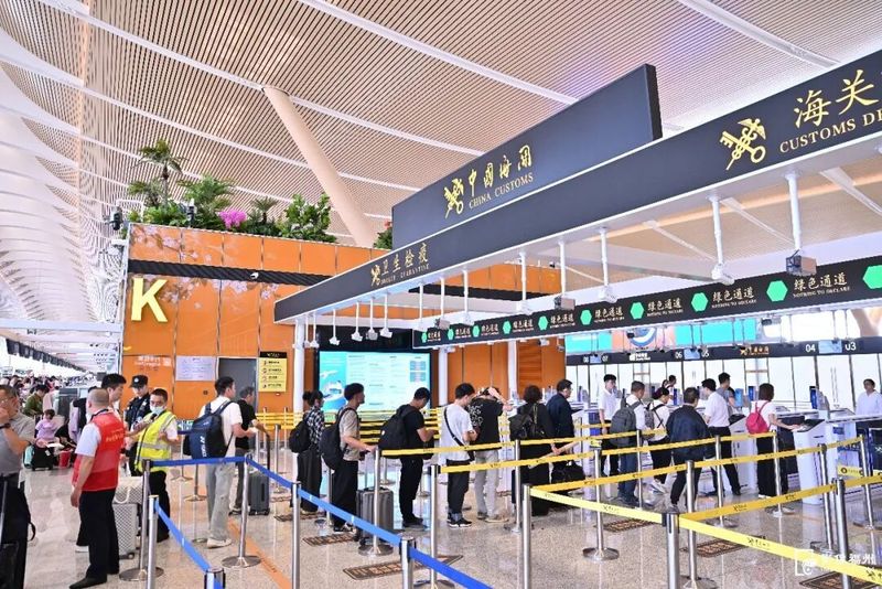 机场海关工作人员引导旅客完成快速通关核验。