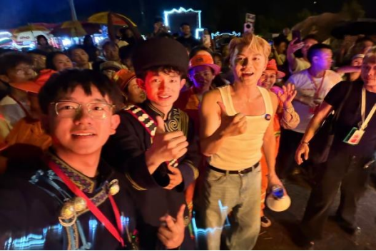 火把节狂欢夜活动现场，李翱（左一）与歌手吴克群（右一）互动交流