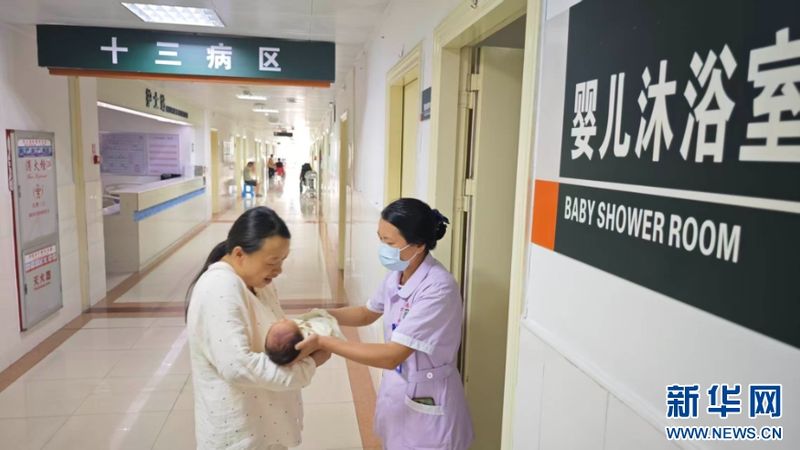 永春县医院里，护理人员将洗浴完毕的新生儿小心交到家属怀中。新华网 刘默涵 摄