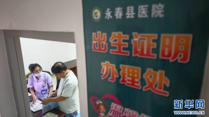 永春县医院出生证明办理处，工作人员为新生儿家属核对材料，办理出生医学证明。新华网 刘默涵 摄