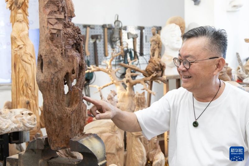 9月20日，在福建泉州惠安，中国工艺美术大师郑国明介绍木雕作品的创作理念。新华社发（连静毅 摄）
