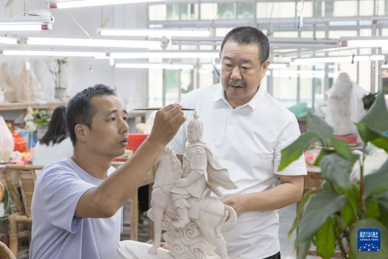 9月19日，在福建泉州德化，中国工艺美术大师林建胜（右）指导徒弟创作陶瓷作品。新华社发（连静毅 摄）