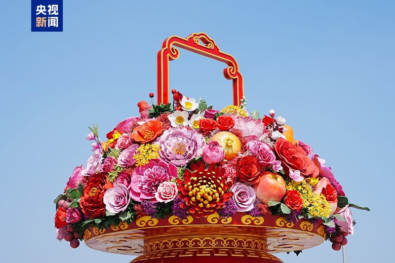 花篮里有月季、牡丹、向日葵、葡萄等花朵和水果，寓意“繁花似锦，硕果累累”。