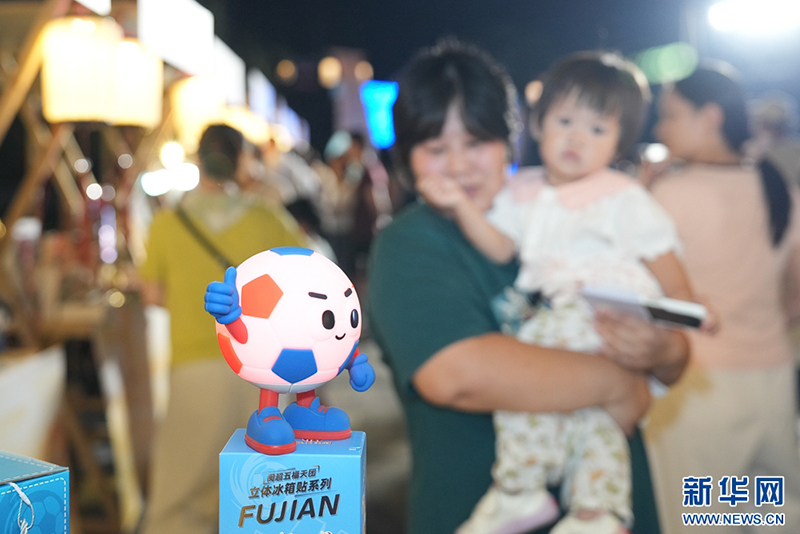 9月25日晚，游客带着孩子逛市集。新华网 肖和勇 摄
