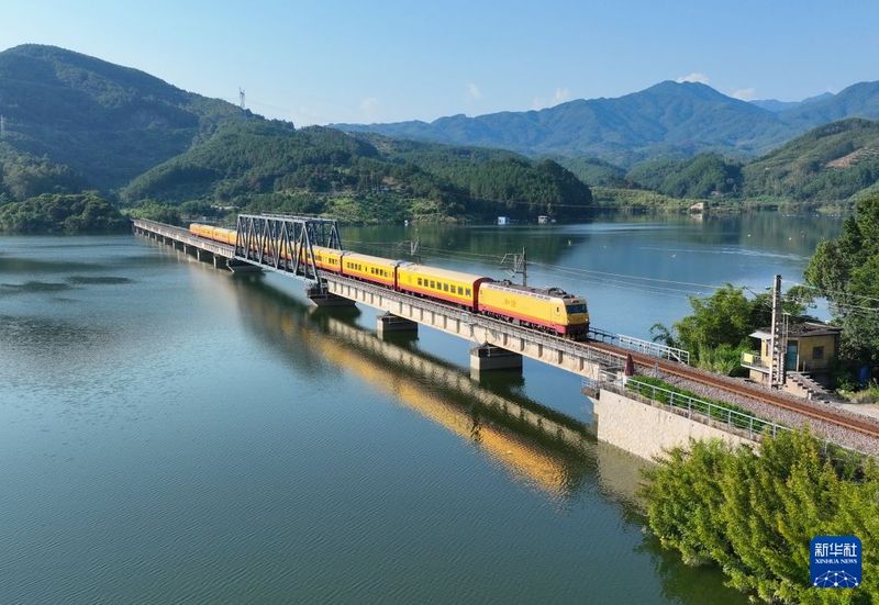 9月25日，从上饶站开往福州站的“武夷山国家公园”主题观光列车通过峰福线古田溪特大桥（无人机照片）。新华社记者 林善传 摄