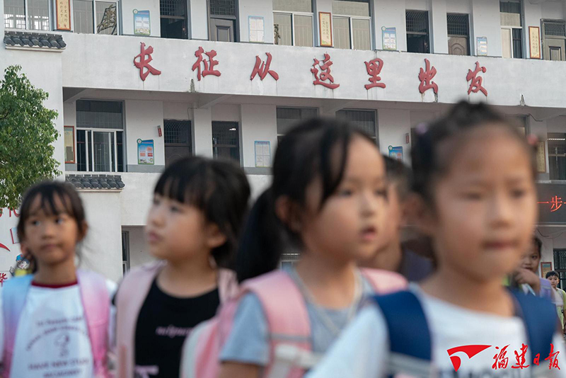 9月29日，中复小学的孩子们放学走出校门，教学楼上长征从这里出发的红字格外醒目，长征的故事也在这里一代代传承。