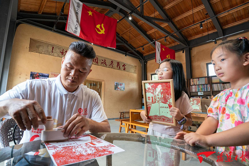 10月1日，在中复村驻村创作的省级非遗刻纸龙灯传承人戴琴炎，带着来参观旅游的孩子们制作红色主题的刻纸作品。