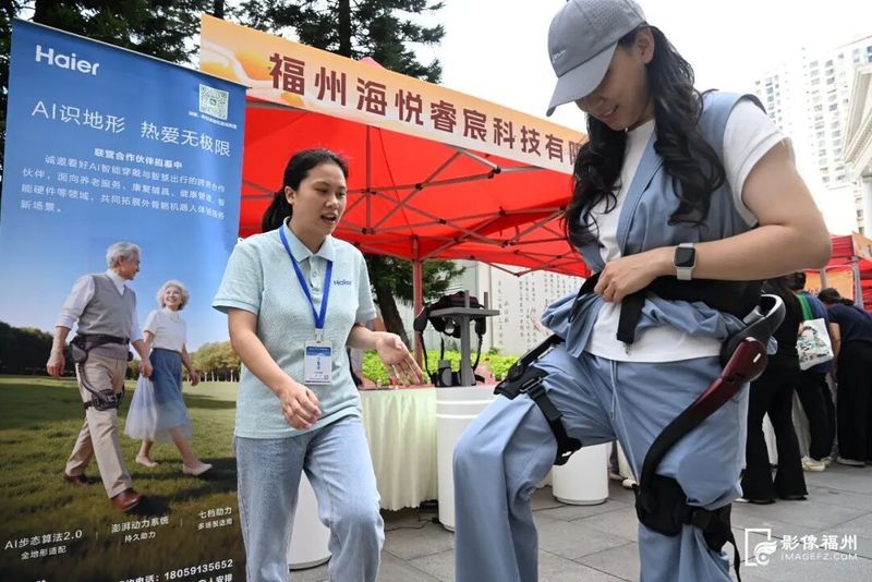 银发经济体验区,市民体验海尔外骨骼机器人。叶诚/摄
