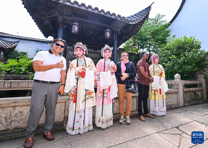 10月18日，在福州三坊七巷水榭戏台景点，嘉宾与闽剧演员合影。新华社记者 姜克红 摄