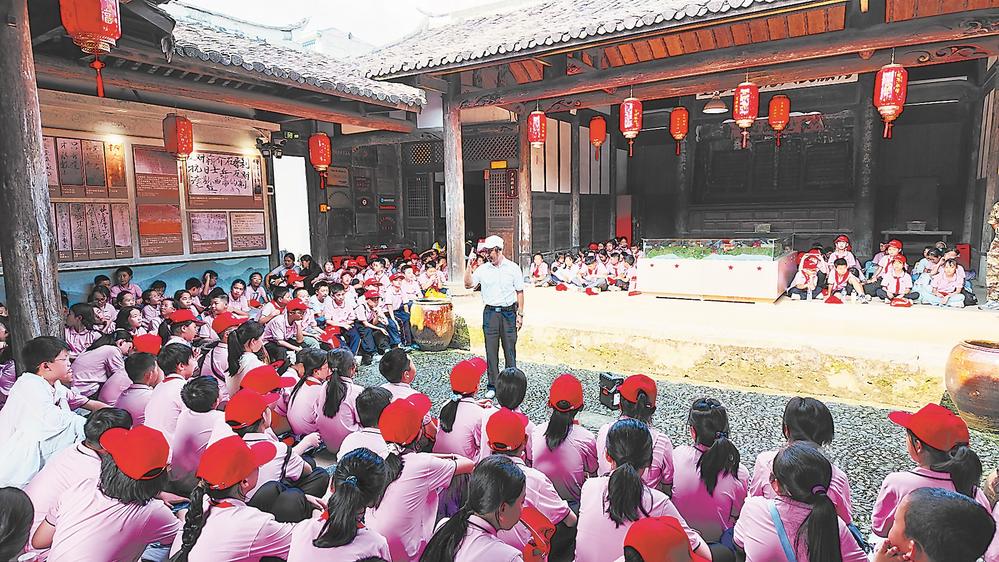 钟鸣(中)在观寿公祠内为参加研学的孩子讲述红色历史。 邱启发 摄