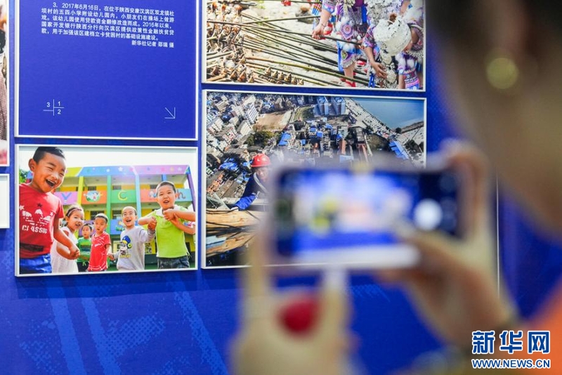 10月20日，参观者用手机拍摄摄影展上的精彩作品。新华网 肖和勇 摄